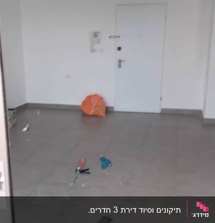 כלי עבודה לצביעה על רצפה בחדר ריק